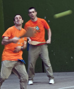 dos personas (una de ellas con discapacidad intelectual) juega a la pelota con unas palas