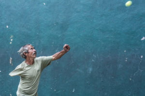 un hombre al que le falta un brazo, juega al frontón