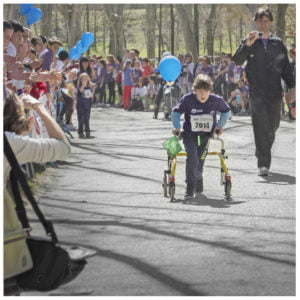 un niño con discapacidad física en una carrera por la ciudad de Madrid