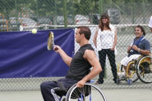 persona en silla de ruedas jugando al tenis