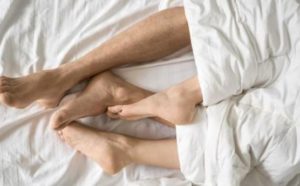 pies de dos personas en una cama