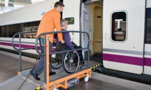 una persona ayuda a subir a un tren a otra en silla de ruedas