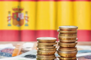 monedas apiladas y la bandera de España de fondo