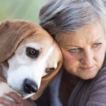 una mujer con discapacidad visual junta su cabeza con la de un perro