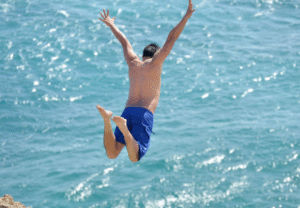 joven saltando hacía el mar