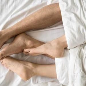 pies de dos personas en una cama