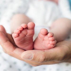 pies de un bebé sujetados por una mano